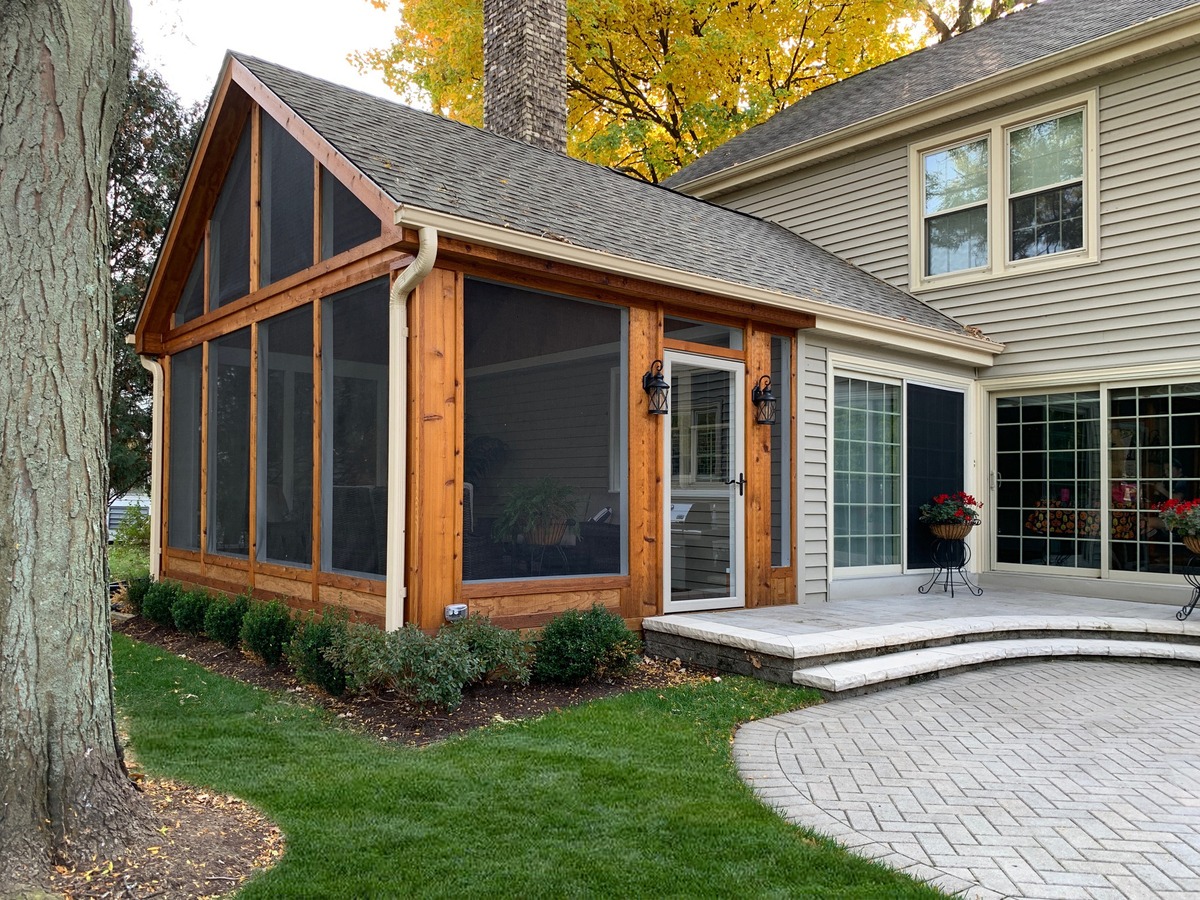 screened in porch on the back of a house with cedar siding
